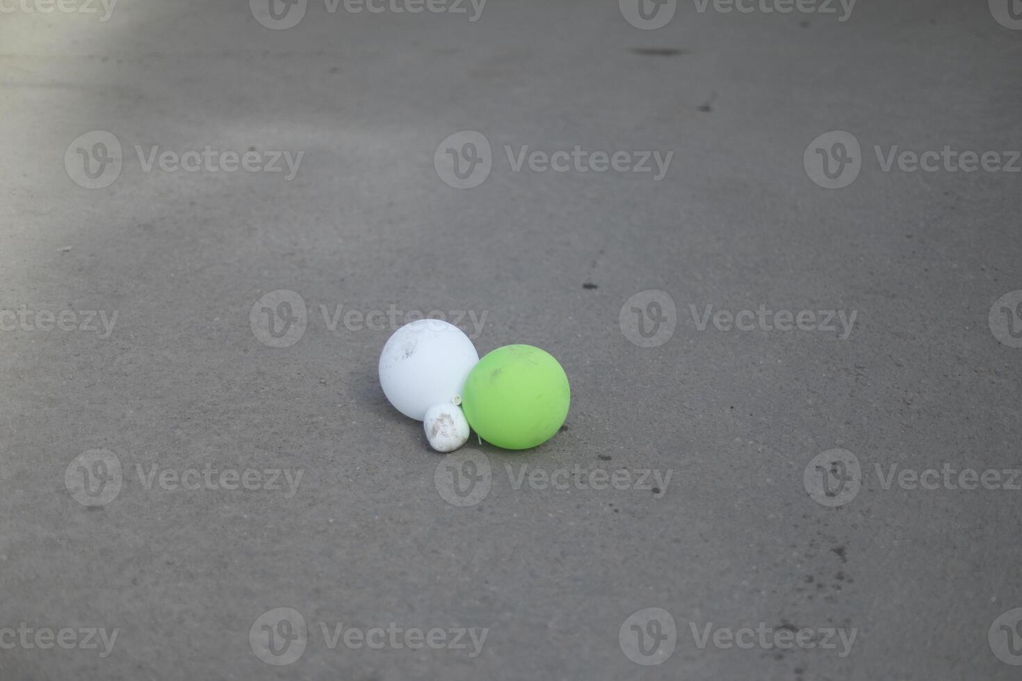Balloons on the road. Garbage after the holiday. Deflated rubber balls. photo