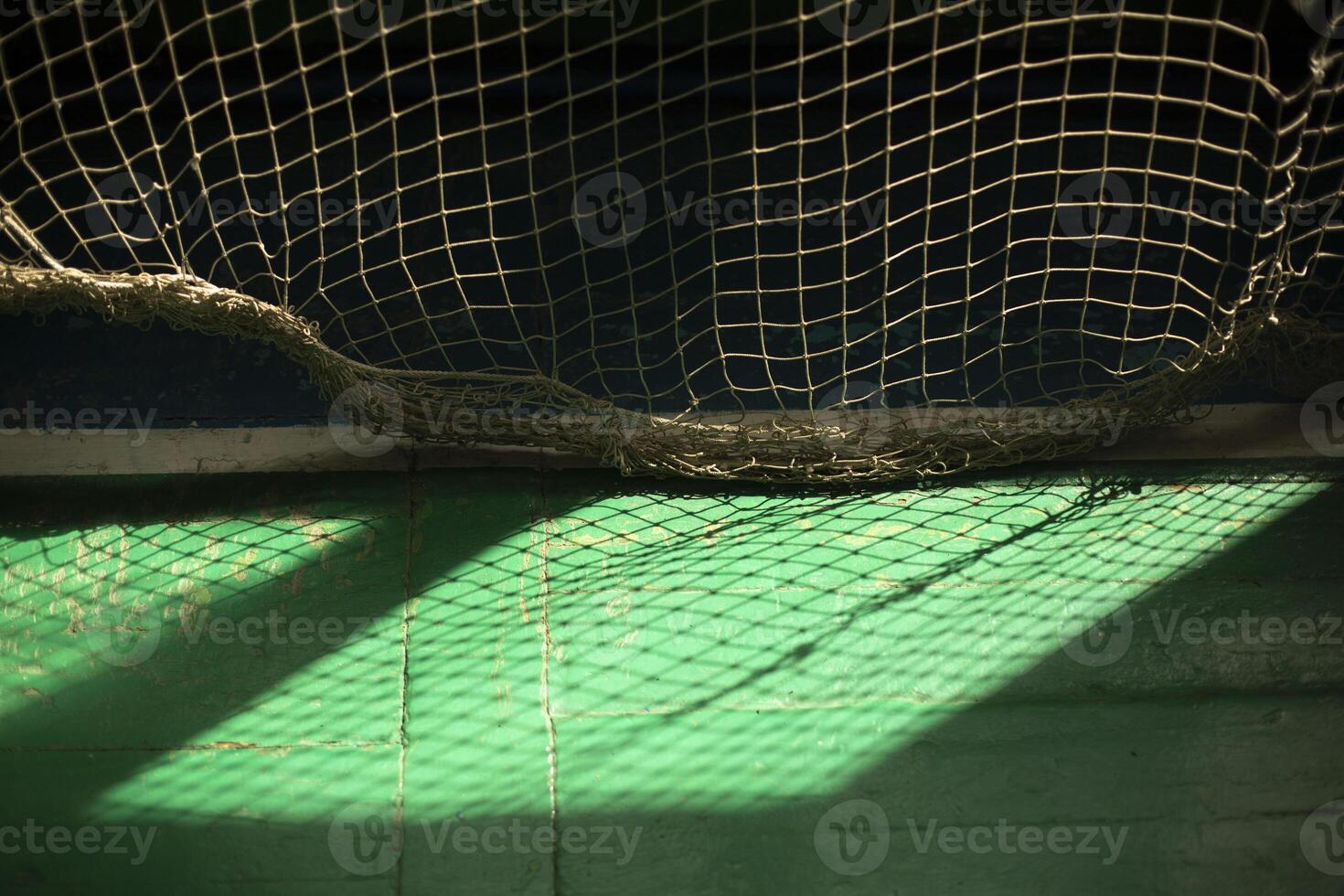 Light through grid. Light in gym. Shadow on floor. photo