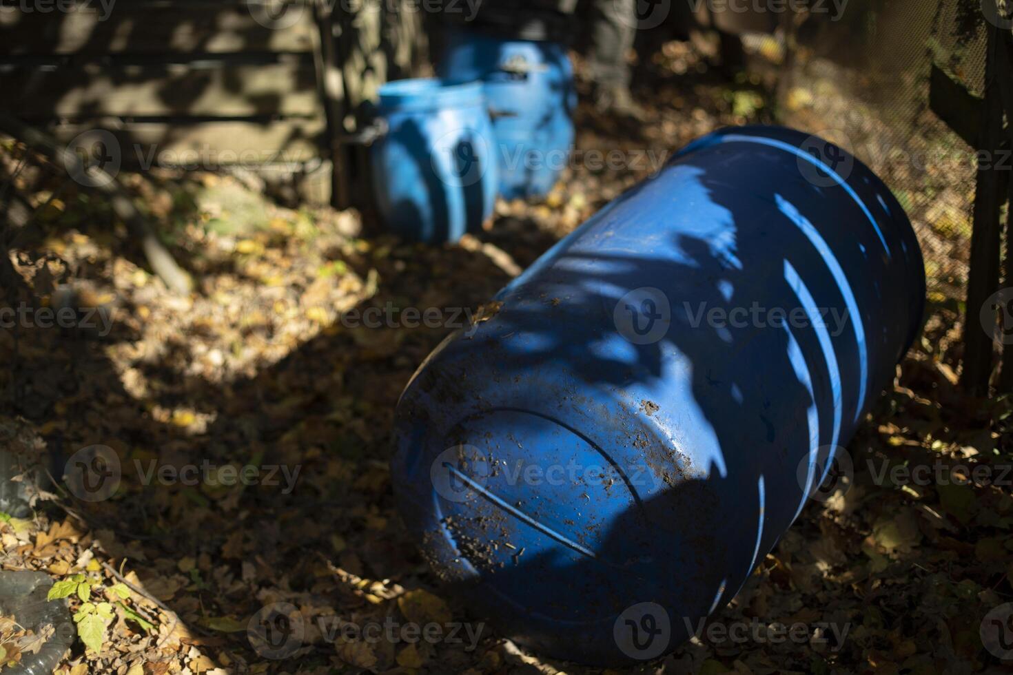 Blue barrel in garden. Water canister. Large tank lies on ground. photo