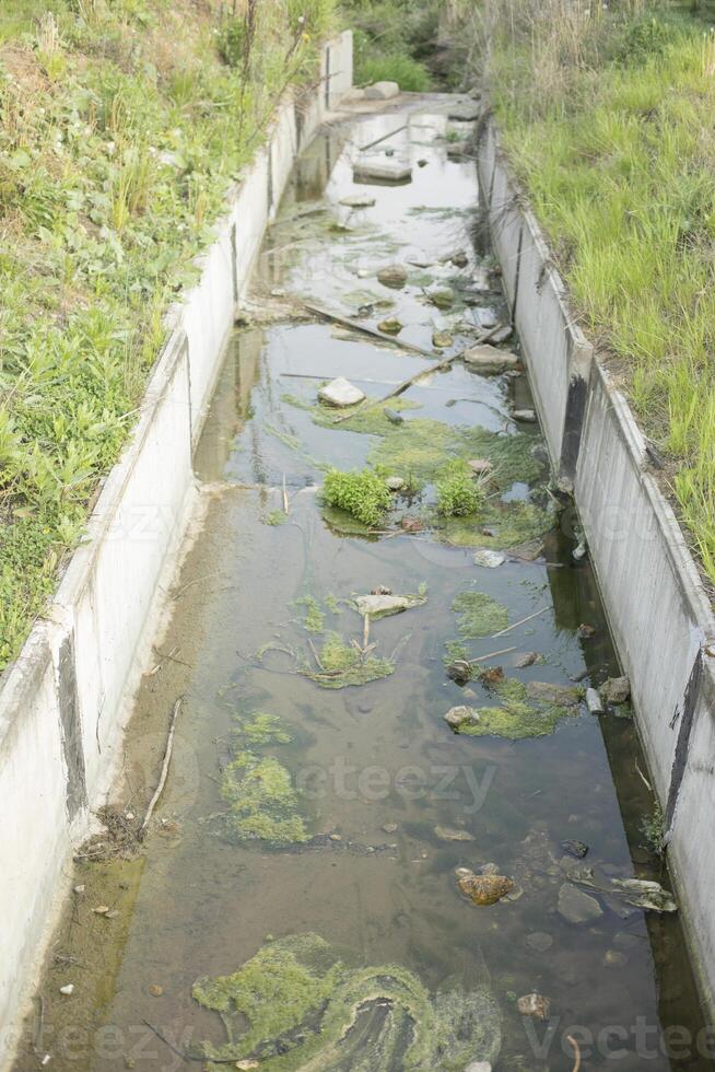 Draining water. Concrete Sewage Channel. Shallow Stream. photo