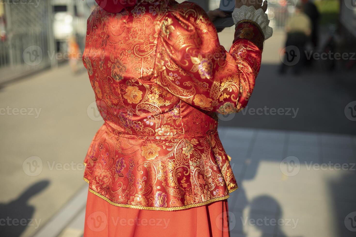 Russian folk costume of red color. Beautiful traditional clothes in Moscow. Outfit details. photo