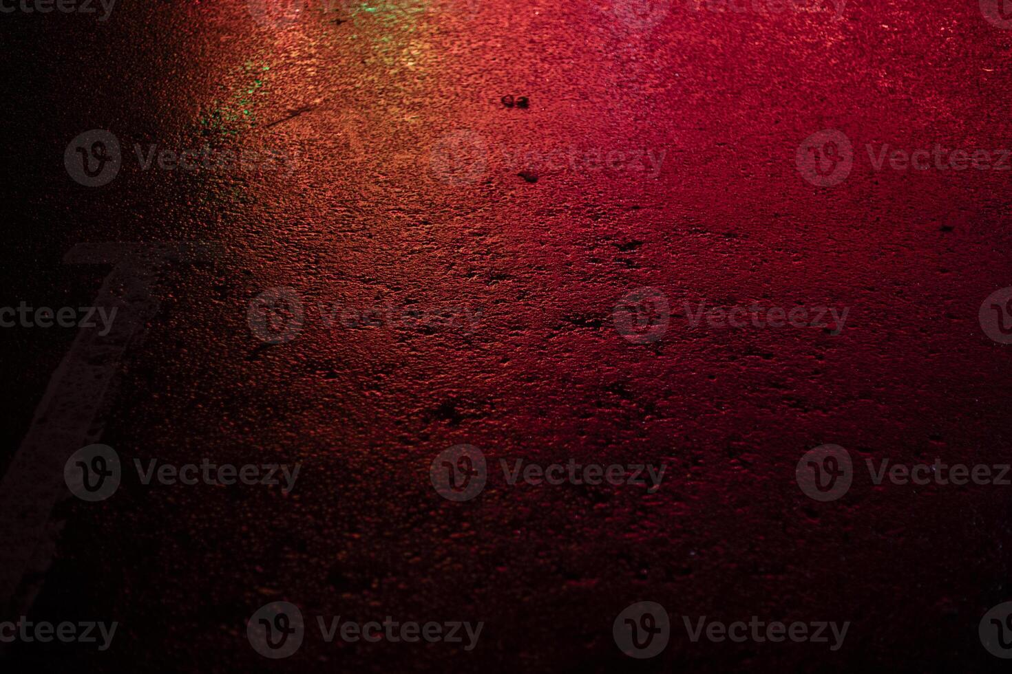 Red light on wet asphalt. Asphalt in a red glow in the evening. Empty parking space. photo