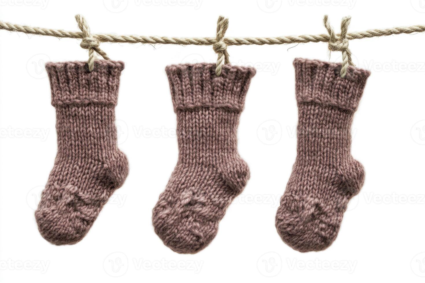 Three pairs of knitted socks hanging on a rope photo