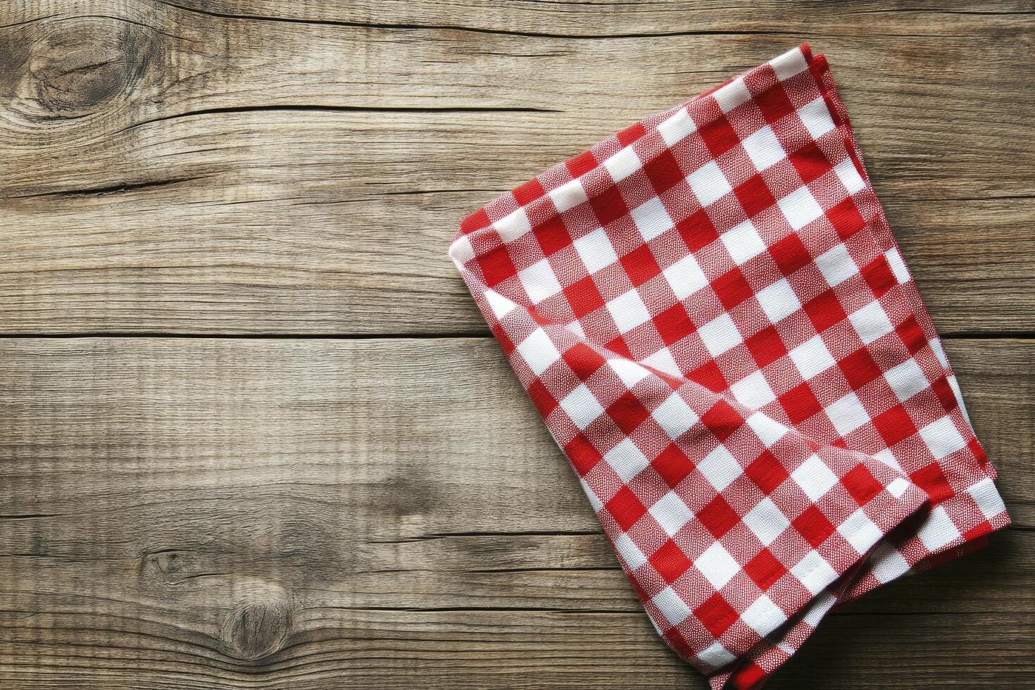 A red and white checkered napkin on a wooden table photo