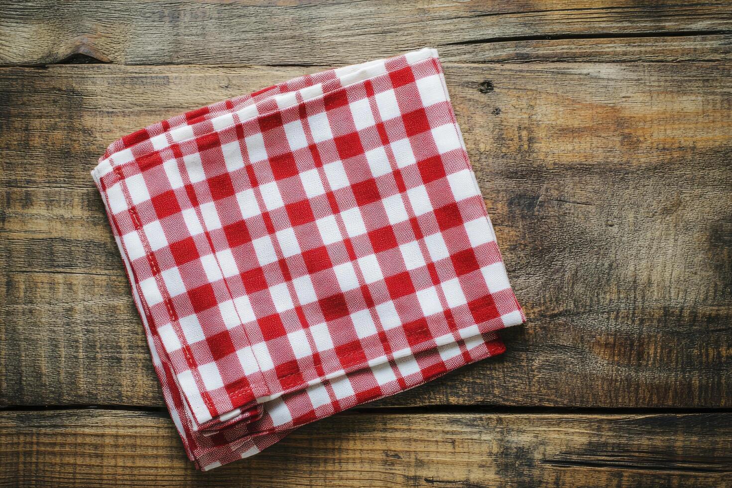 A red and white checkered napkin on a wooden table photo