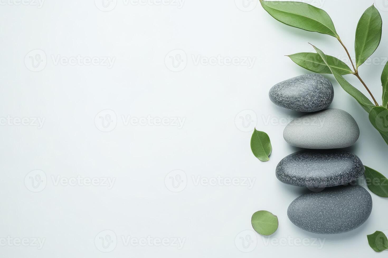 Spa stones and green leaves on white background photo