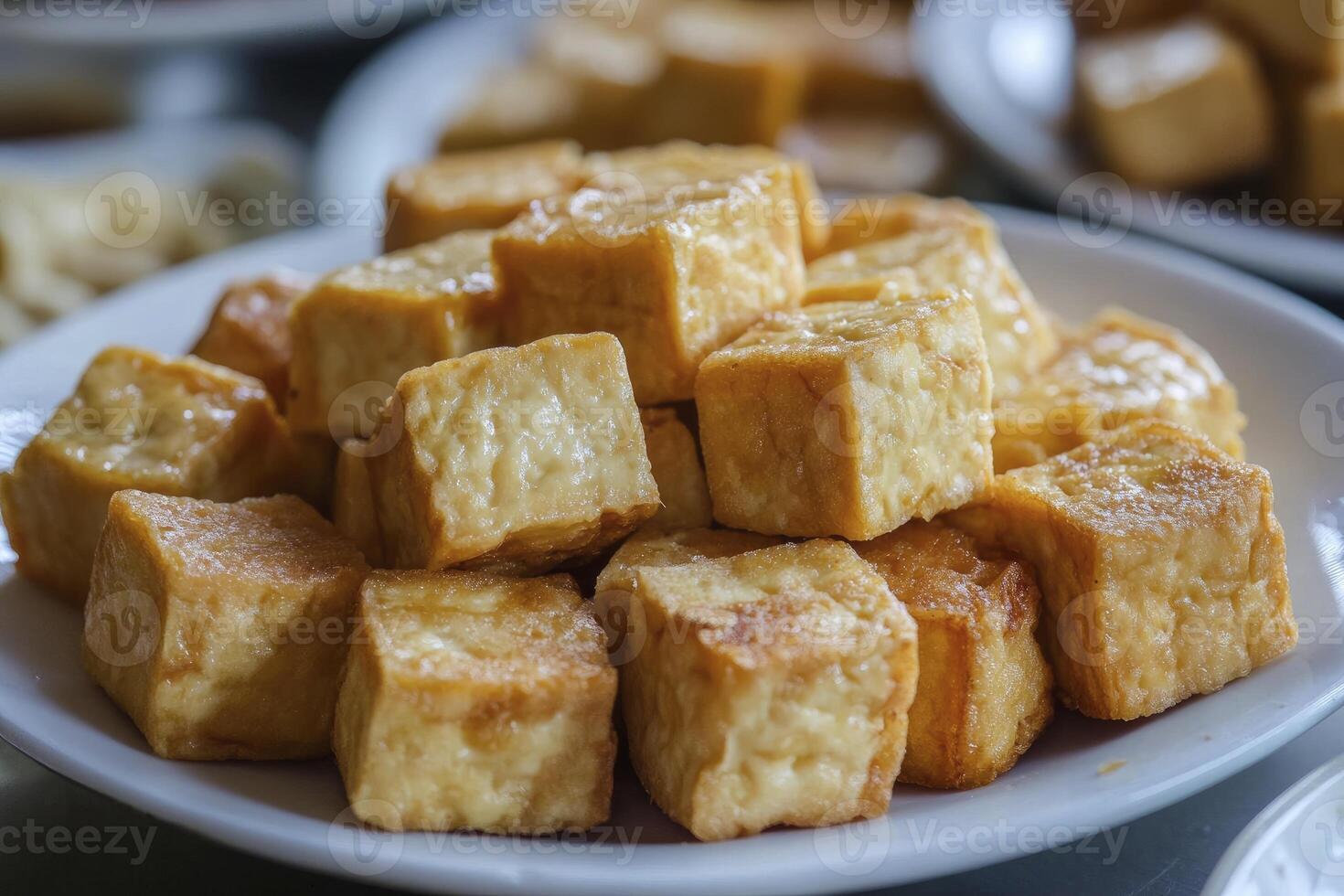 A plate of tofu cubes sitting on a table photo