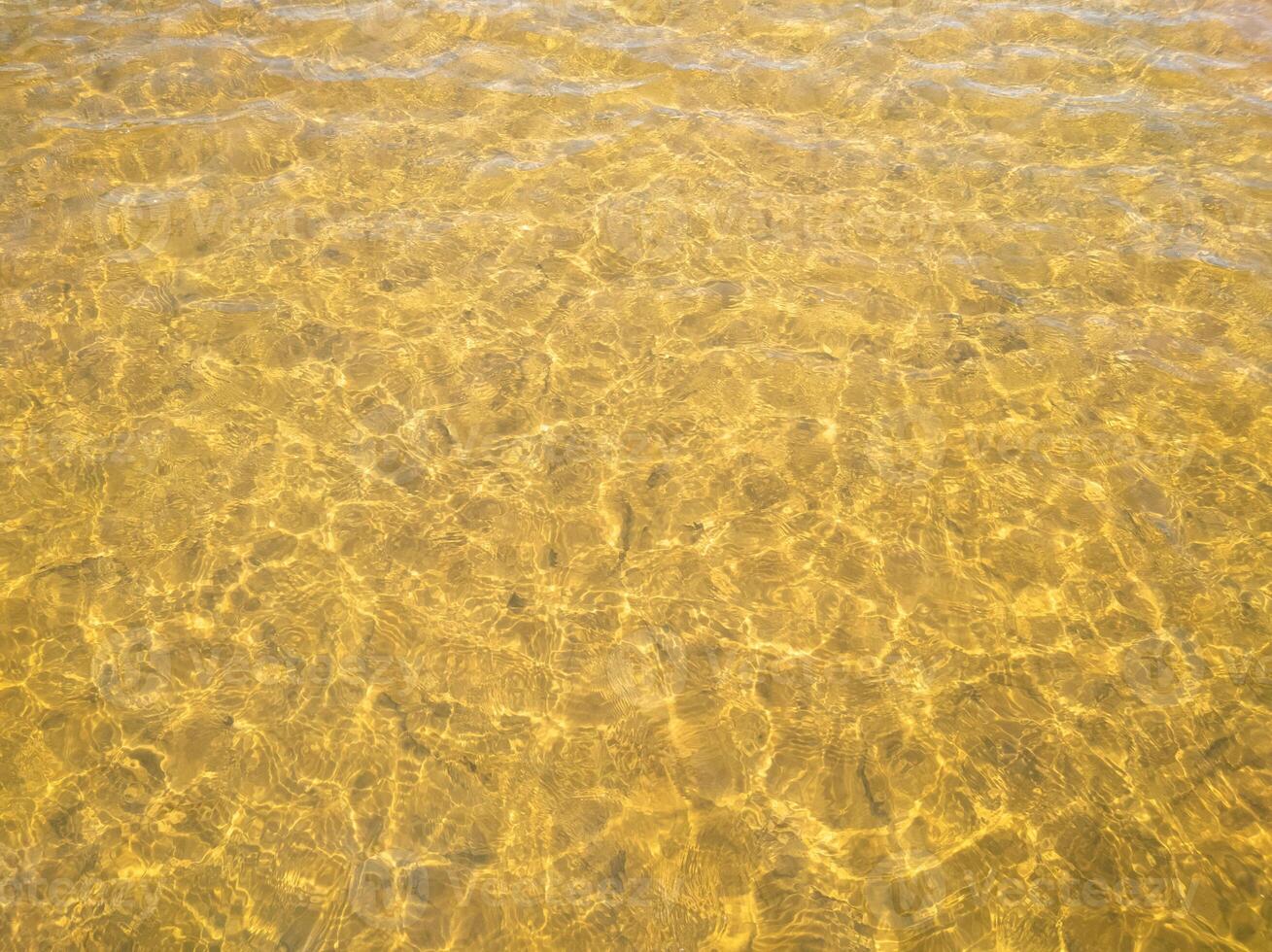 Abstract background. Golden river water surface with sun reflections photo