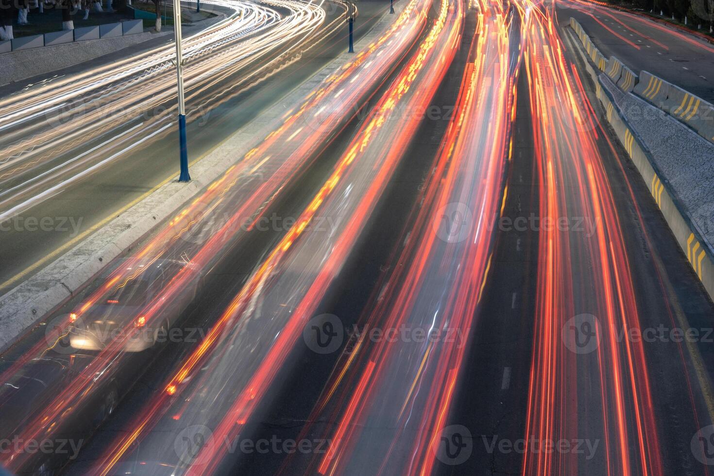 City road background with automobile light trails blurred headlights in the evening photo