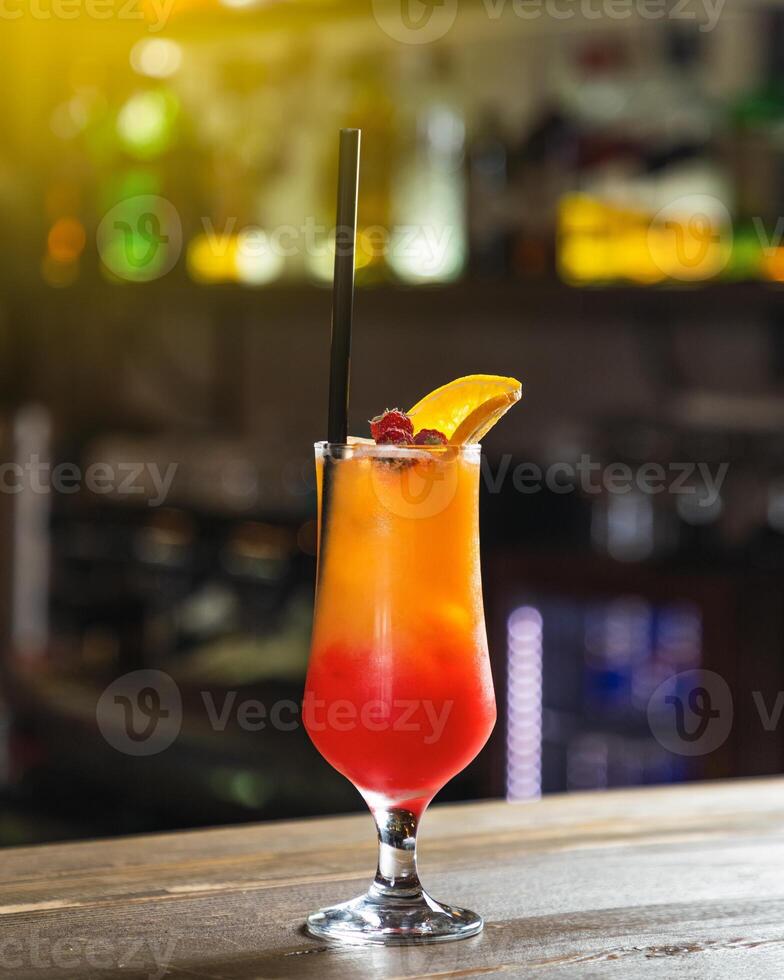 Alcoholic cocktail standing on bar counter with blurry background photo