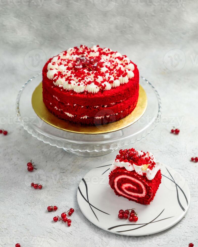 Delicious red velvet roll cake and layered cake decorated with redcurrants on white background photo