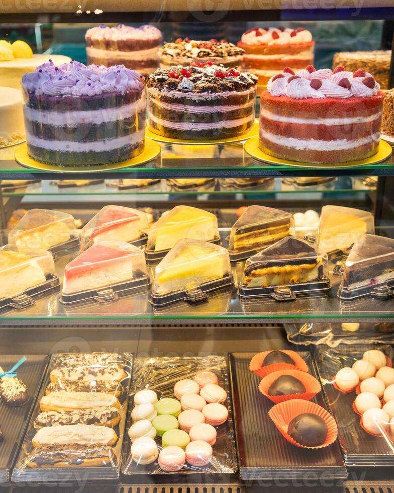Display of delicious cakes and pastries tempting customers in bakery shop window photo