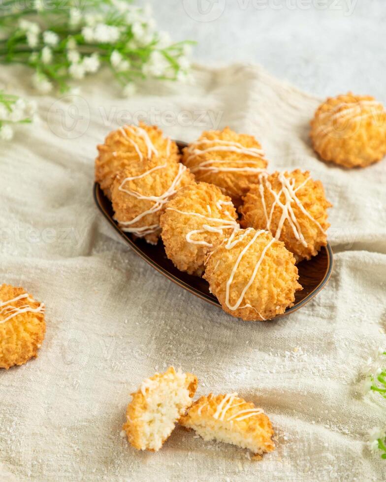 Small coconut cookies with white chocolate are lying on a plate photo