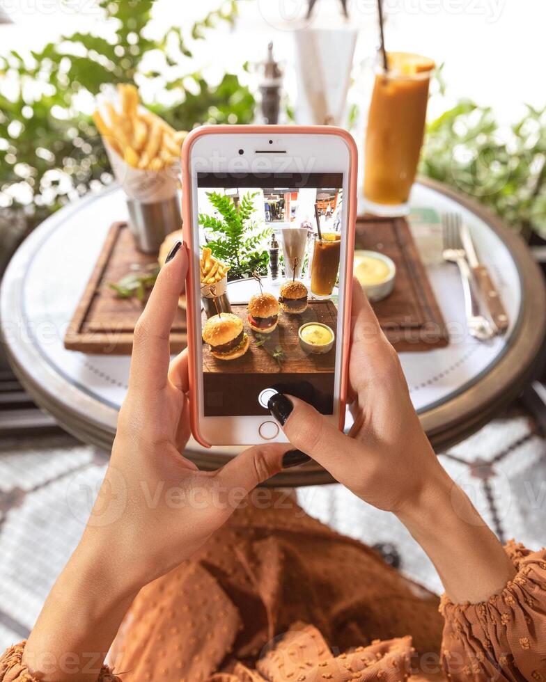 Woman taking picture of a burger menu at restaurant photo