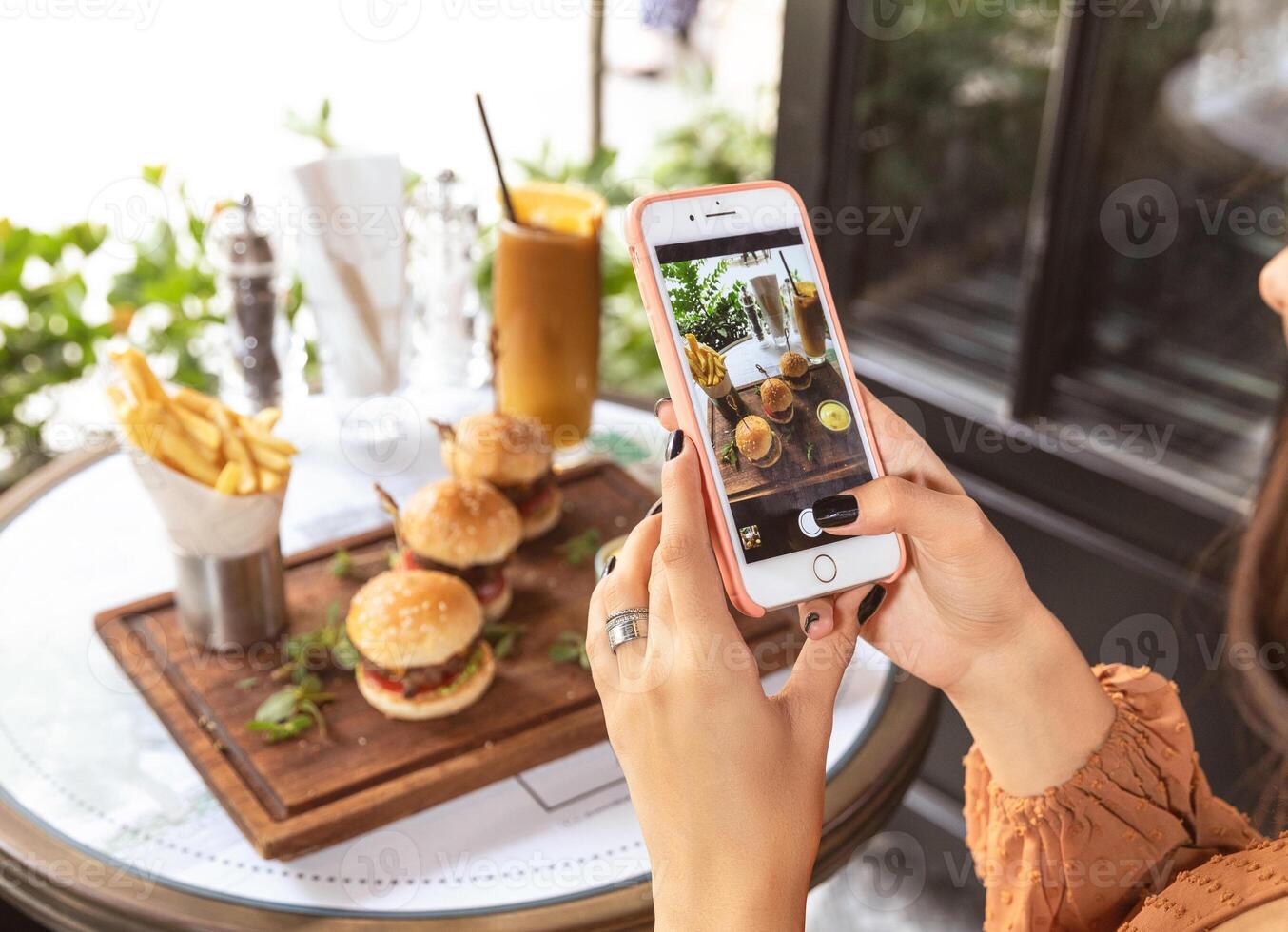 Woman taking picture of a burger menu at restaurant photo