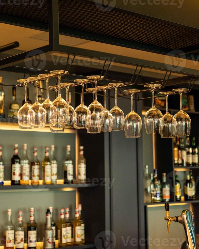 Wine glasses hanging over bar counter in restaurant photo