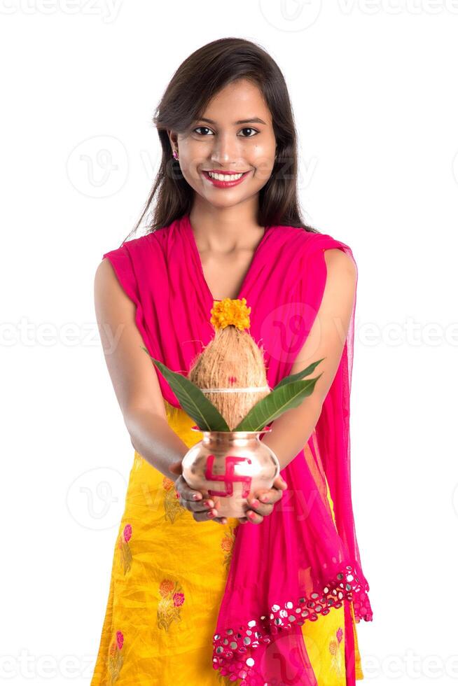 Indian girl holding a traditional copper Kalash, Indian Festival, copper Kalash with coconut and mango leaf with floral decoration, essential in Hindu Pooja. photo