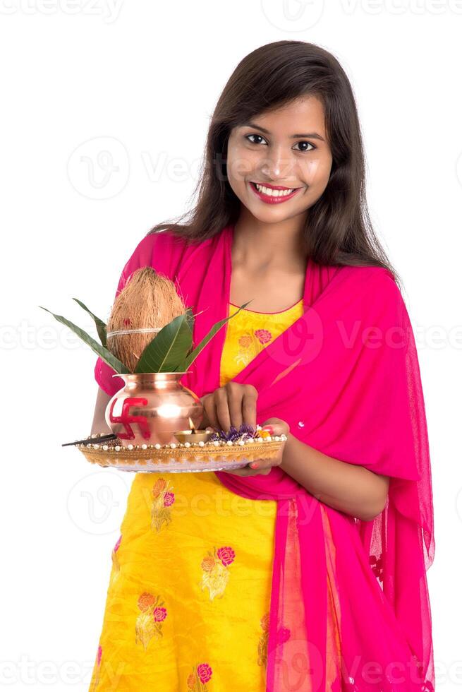 Indian girl holding a traditional copper Kalash with Pooja Thali, Indian Festival, copper Kalash with coconut and mango leaf with floral decoration, essential in Hindu Pooja. photo