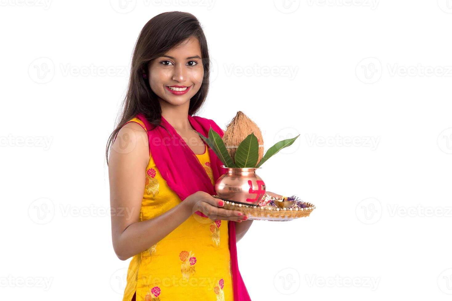Indian girl holding a traditional copper Kalash with Pooja Thali, Indian Festival, copper Kalash with coconut and mango leaf with floral decoration, essential in Hindu Pooja. photo