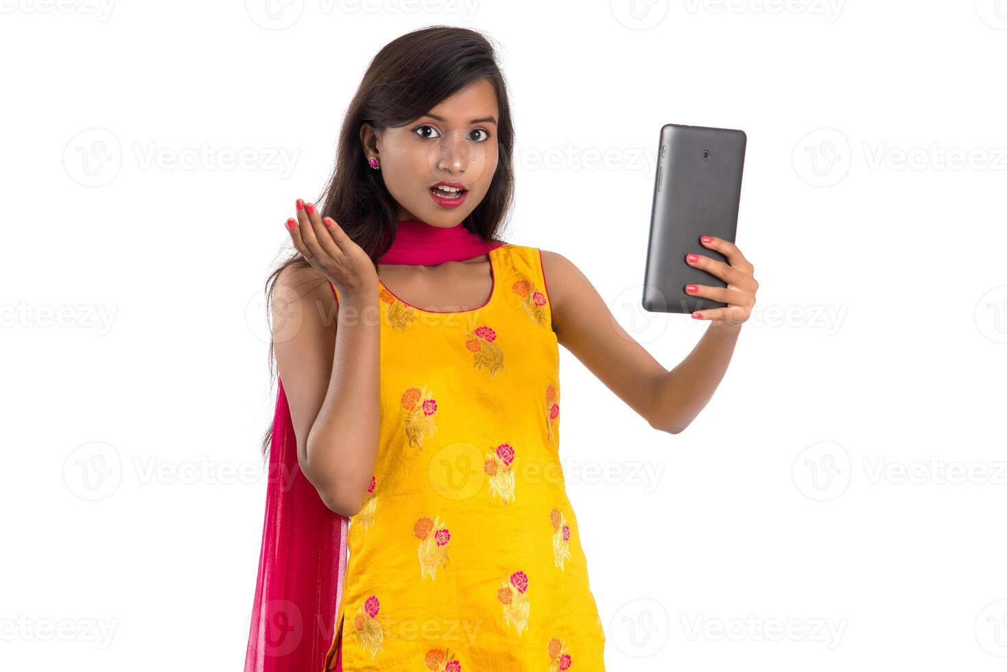 Young Indian girl using a Tablet, mobile phone or smartphone isolated on a white background photo