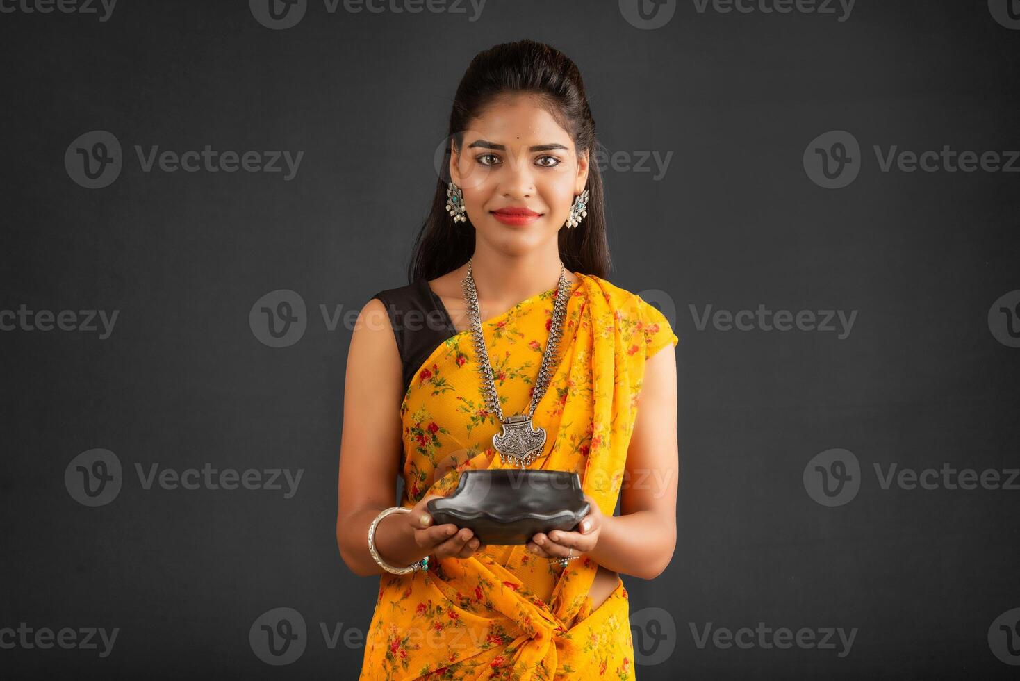 Young girl holding and posing with kitchen utensils on a grey background photo