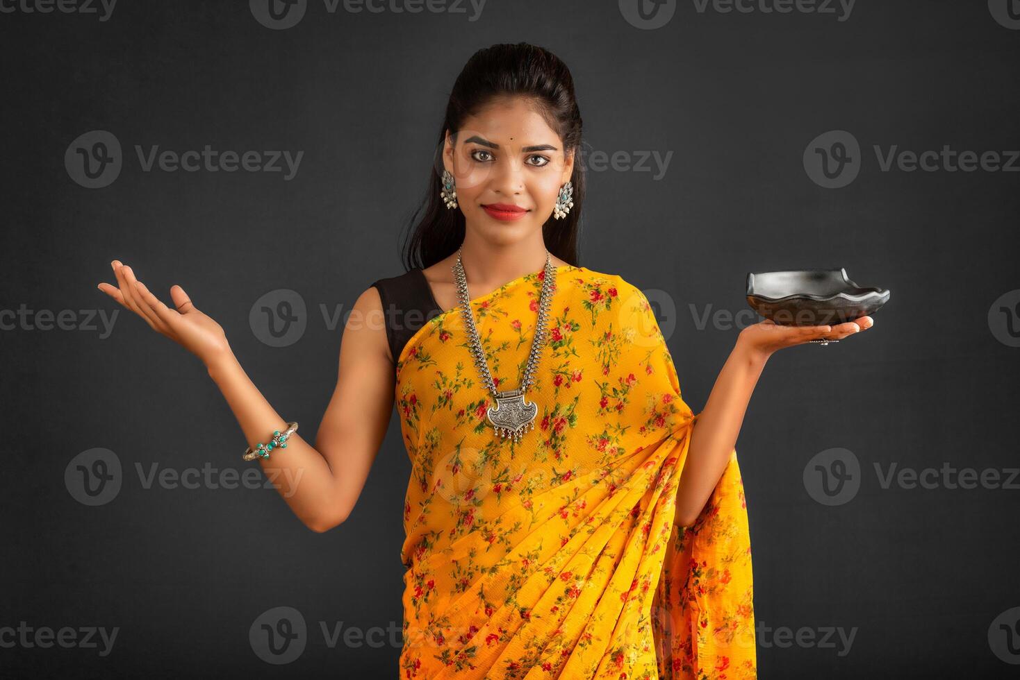Young girl holding and posing with kitchen utensils on a grey background photo
