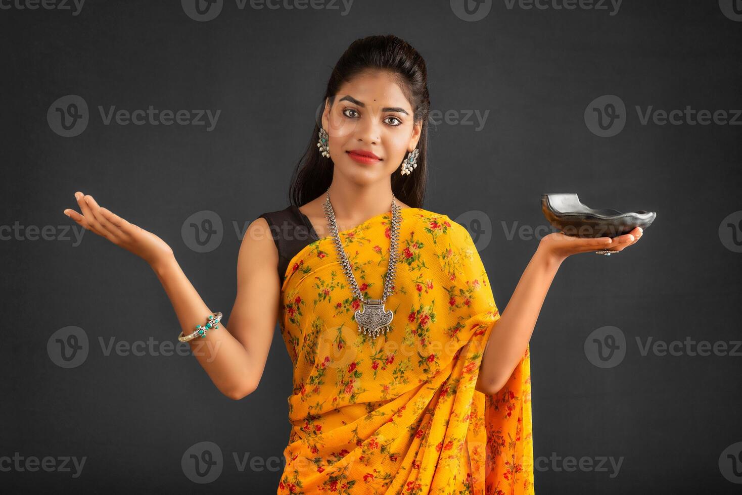 Young girl holding and posing with kitchen utensils on a grey background photo