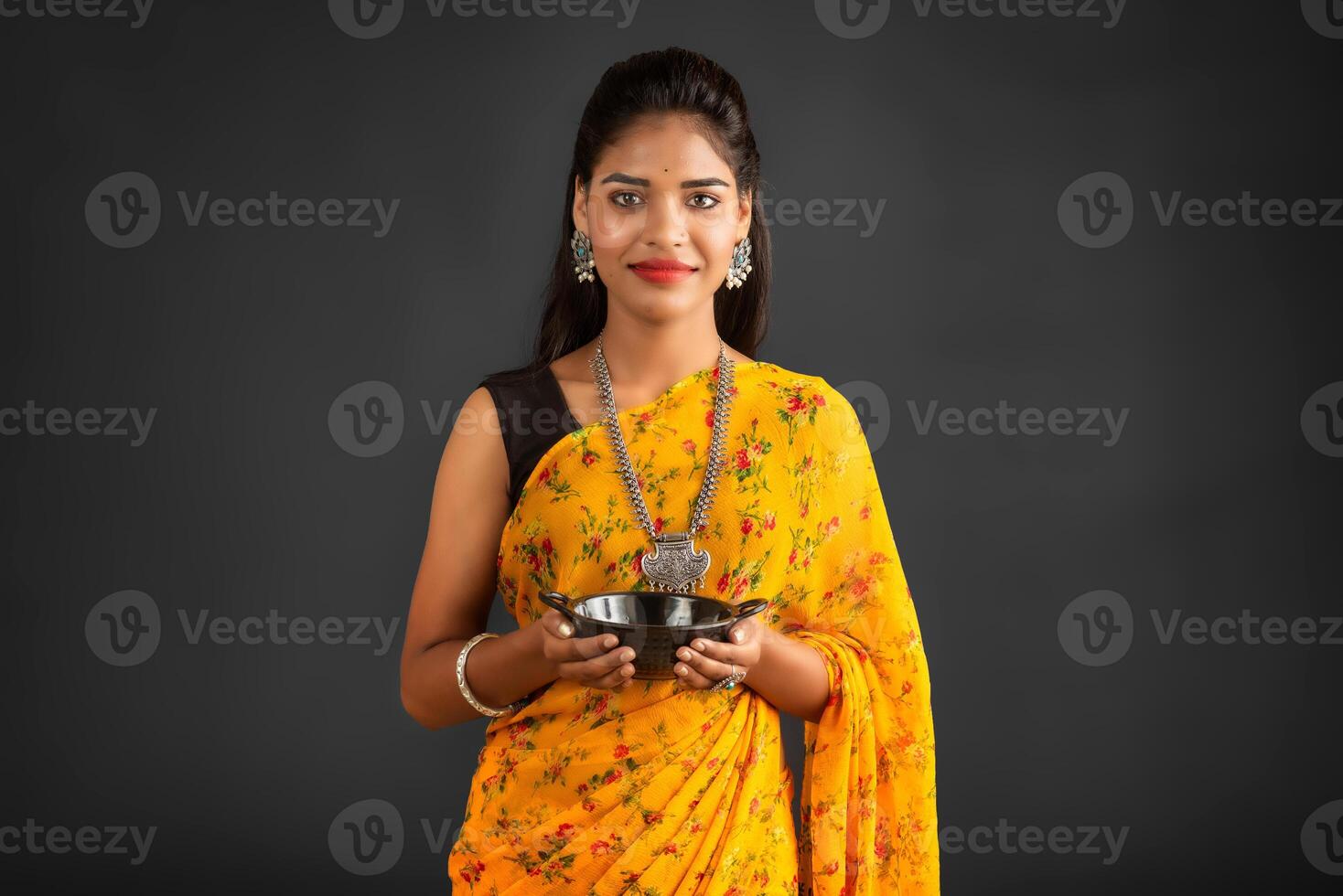 Young girl holding and posing with kitchen utensils on a grey background photo