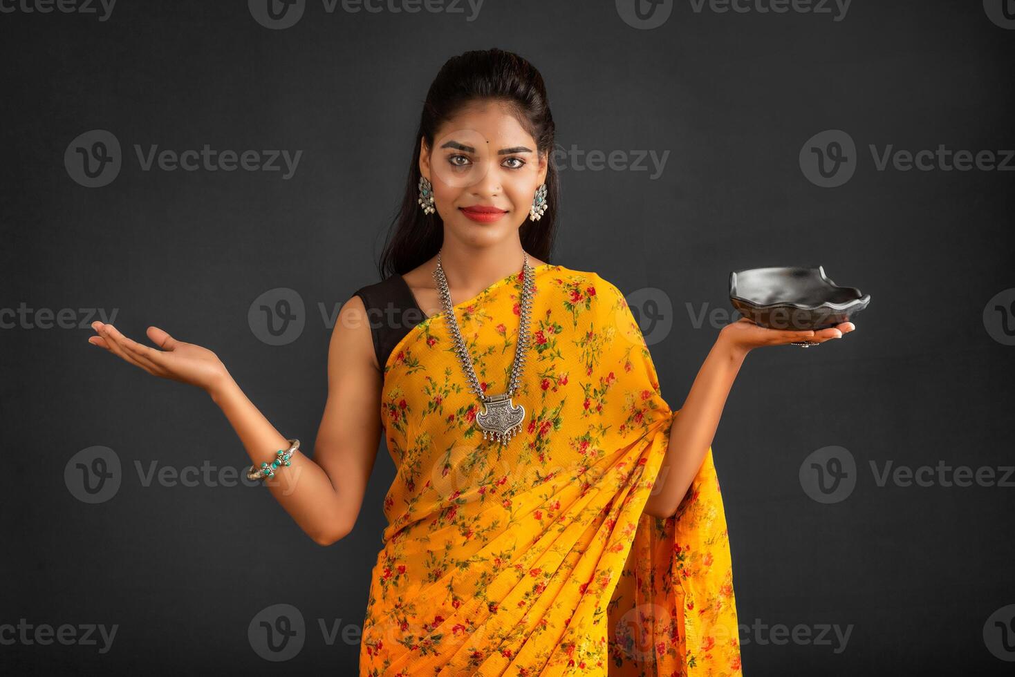Young girl holding and posing with kitchen utensils on a grey background photo
