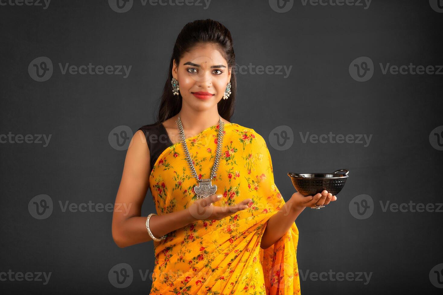 Young girl holding and posing with kitchen utensils on a grey background photo