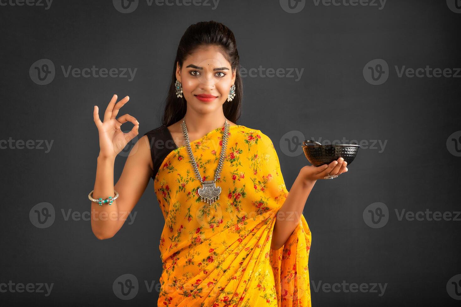Young girl holding and posing with kitchen utensils on a grey background photo
