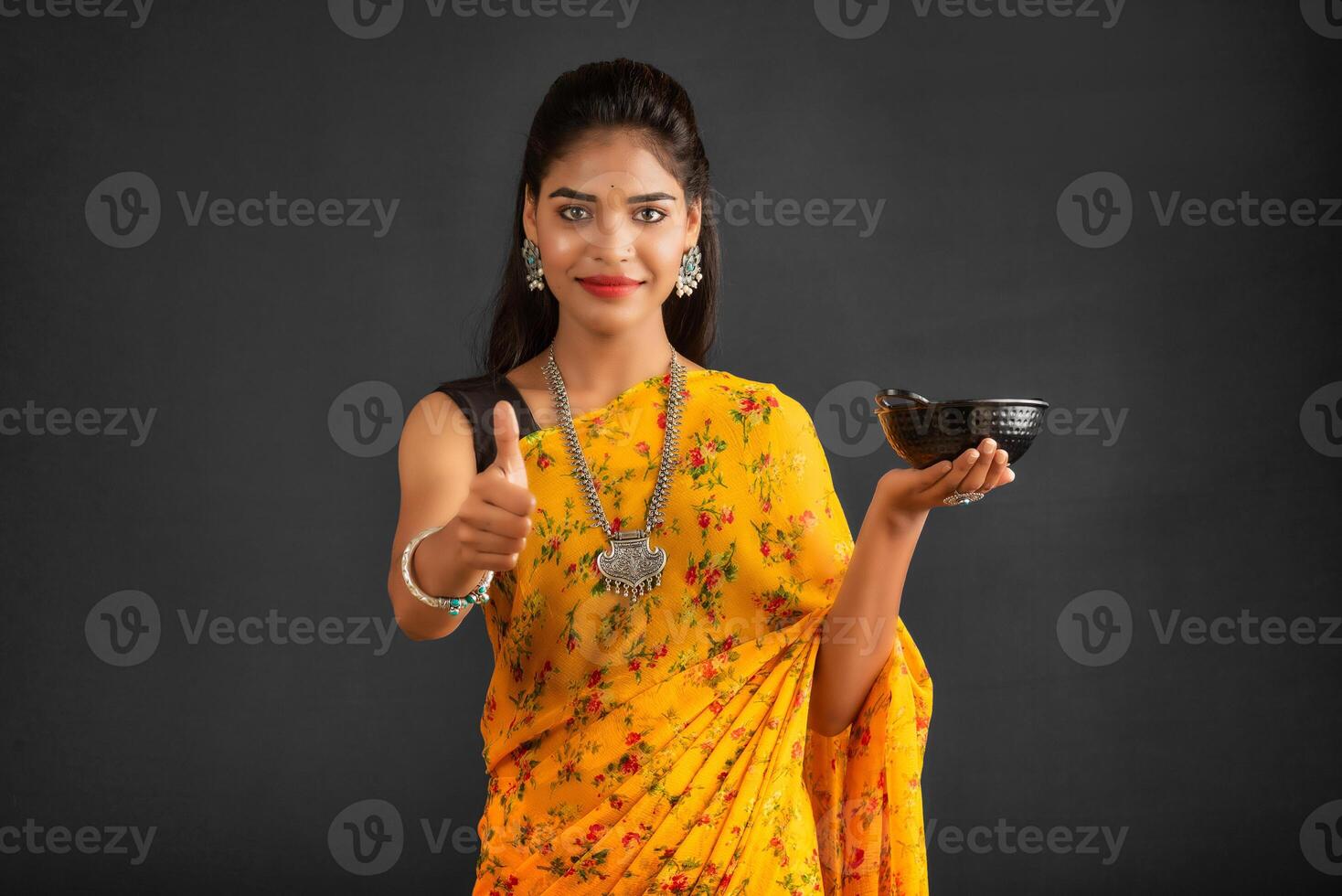 Young girl holding and posing with kitchen utensils on a grey background photo