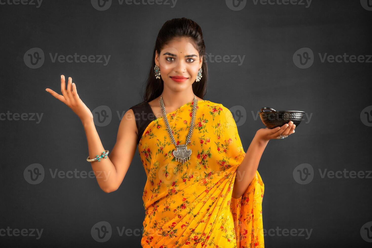 Young girl holding and posing with kitchen utensils on a grey background photo