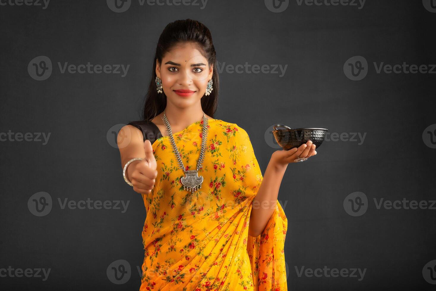 Young girl holding and posing with kitchen utensils on a grey background photo
