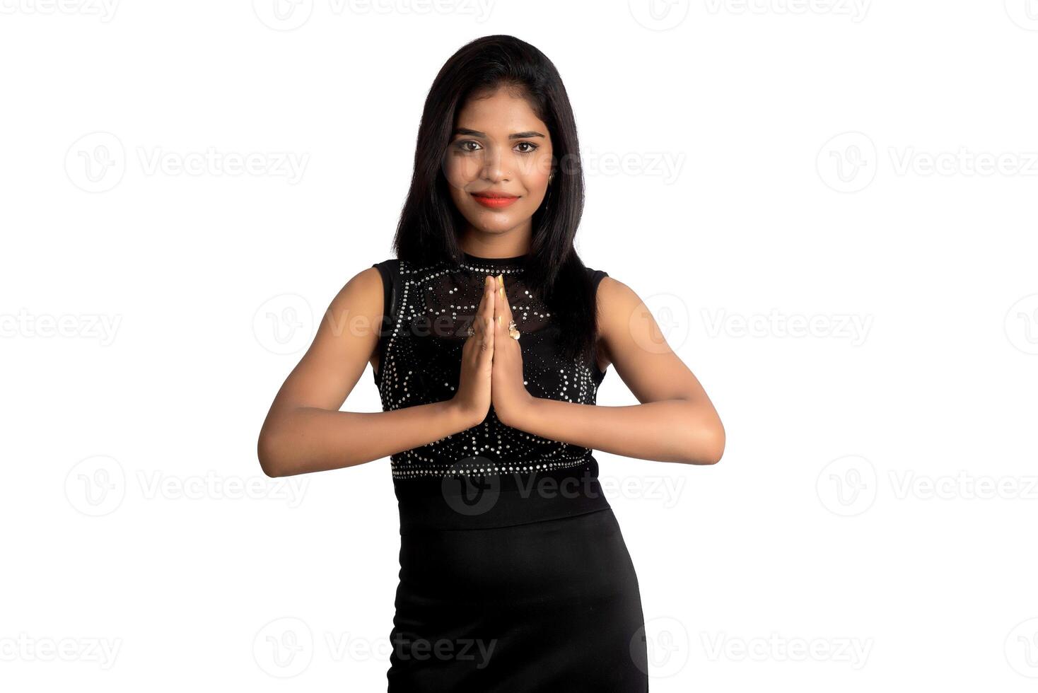 Beautiful Indian girl with welcome expression or inviting or greeting Namaste on a white background. photo