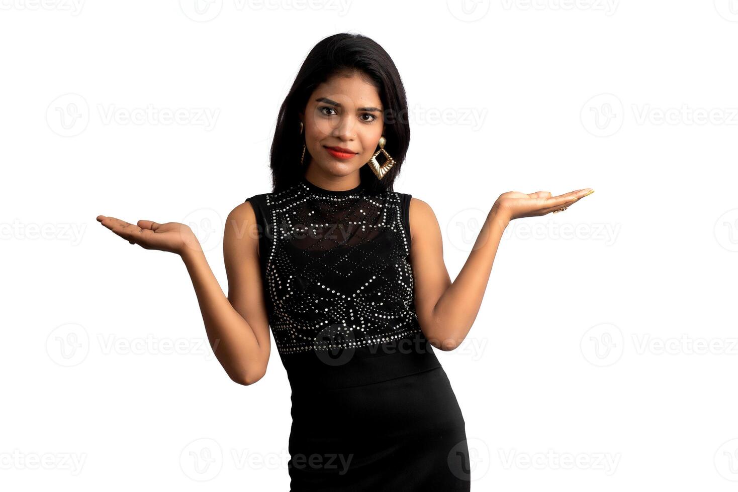 Portrait of a successful cheerful young girl pointing and presenting something with hand or finger with a happy smiling face. photo