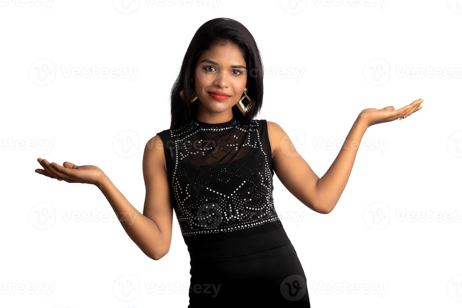 Portrait of a successful cheerful young girl pointing and presenting something with hand or finger with a happy smiling face. photo