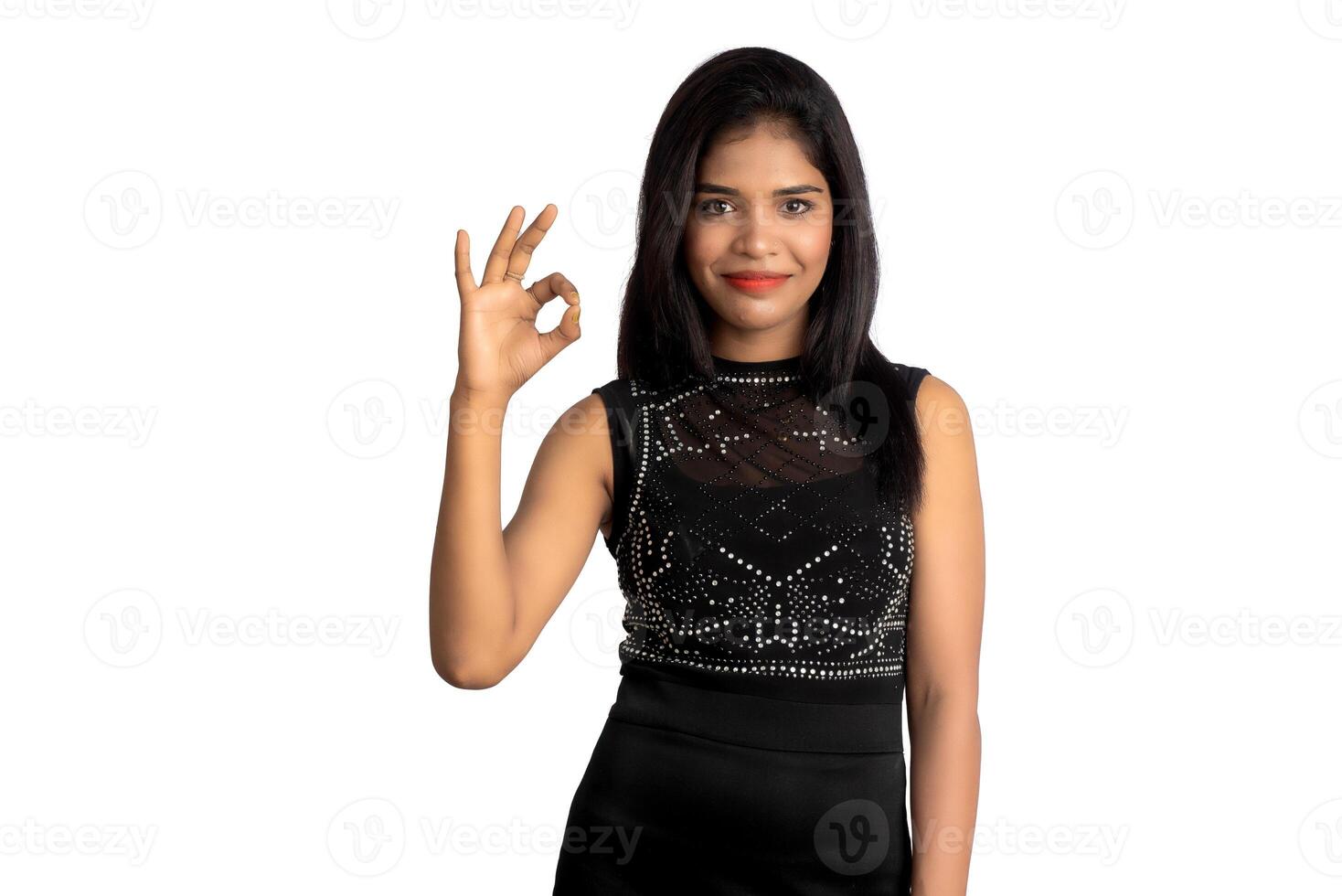 Portrait of a successful cheerful young girl pointing and presenting something with hand or finger with a happy smiling face. photo