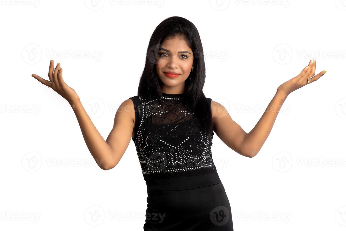 Portrait of a successful cheerful young girl pointing and presenting something with hand or finger with a happy smiling face. photo