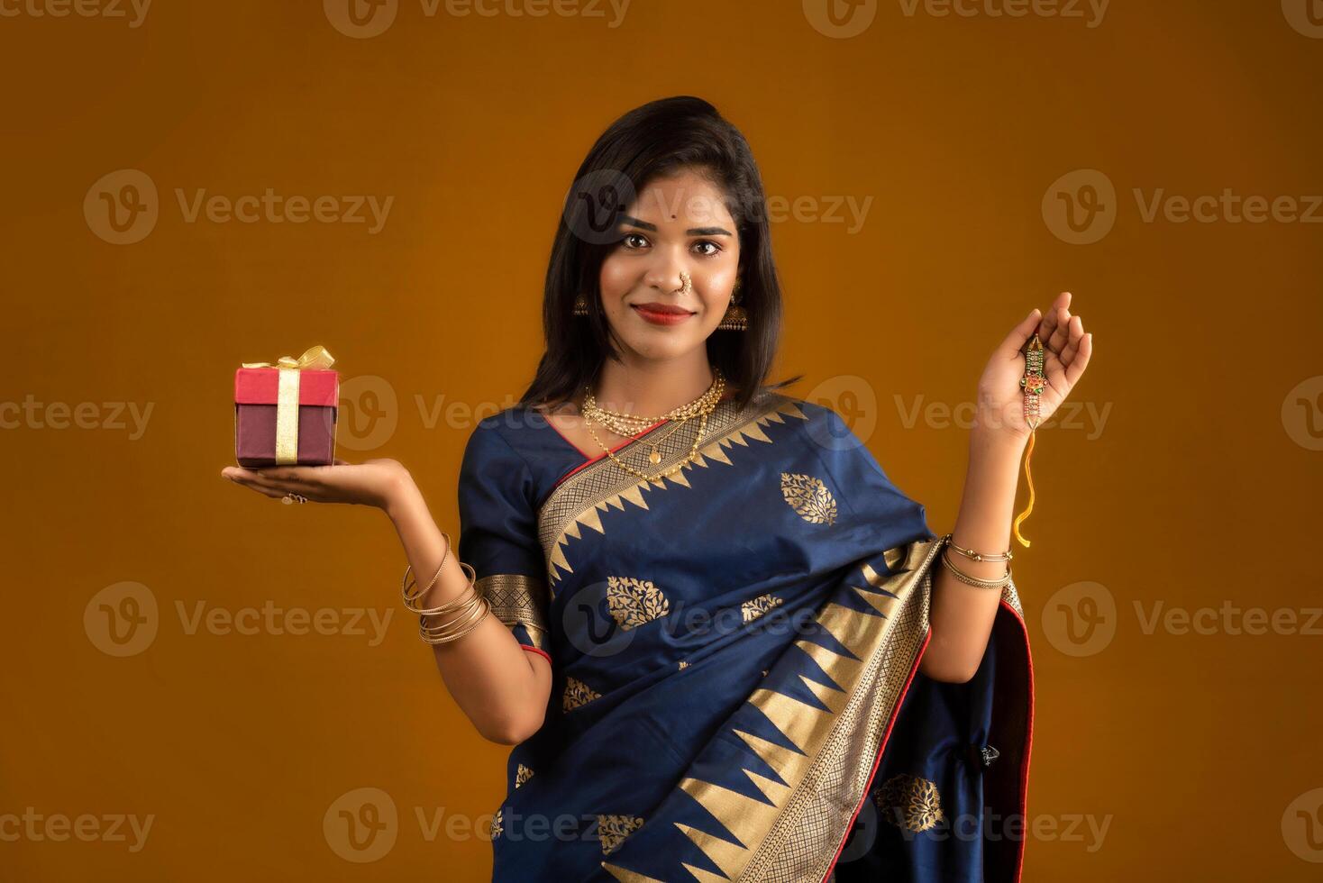 Beautiful Indian girl showing Rakhis and the gift box on the occasion of Raksha Bandhan. photo