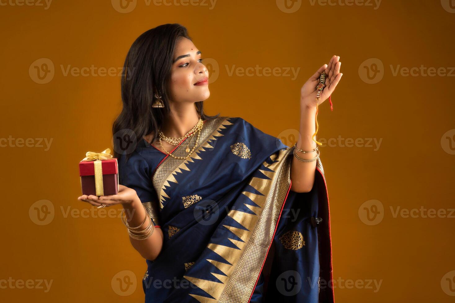 Beautiful Indian girl showing Rakhis and the gift box on the occasion of Raksha Bandhan. photo
