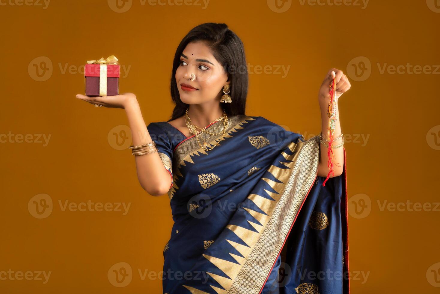 Beautiful Indian girl showing Rakhis and the gift box on the occasion of Raksha Bandhan. photo