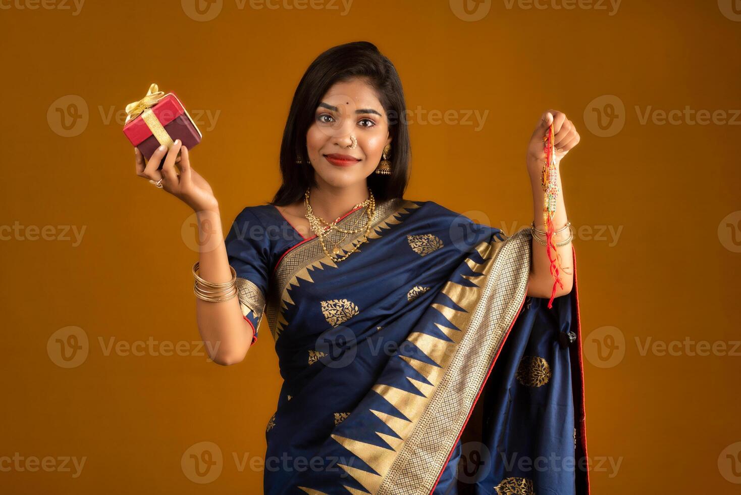 Beautiful Indian girl showing Rakhis and the gift box on the occasion of Raksha Bandhan. photo