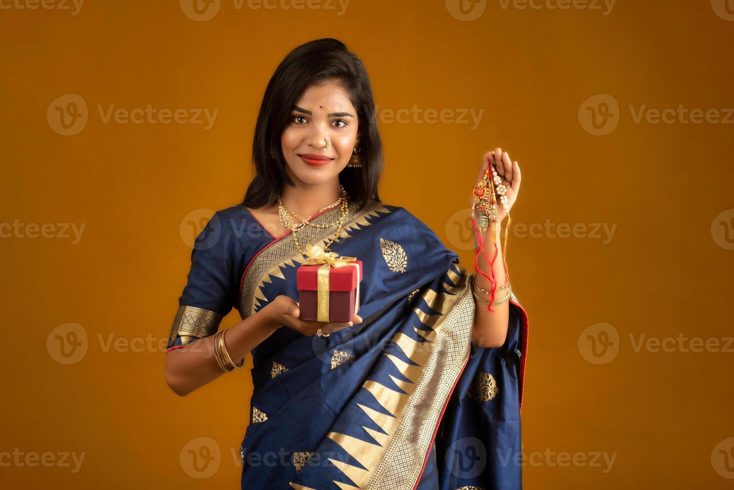 Beautiful Indian girl showing Rakhis and the gift box on the occasion of Raksha Bandhan. photo
