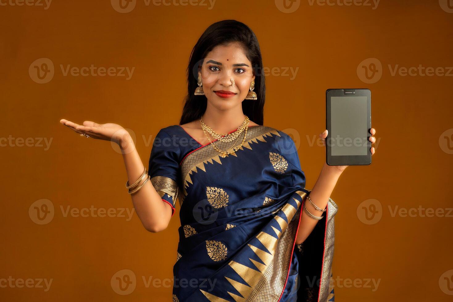 Young beautiful girl showing a blank screen of smartphone or mobile or tablet phone photo