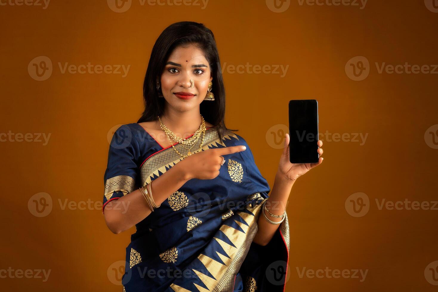 Young beautiful girl showing a blank screen of smartphone or mobile or tablet phone photo