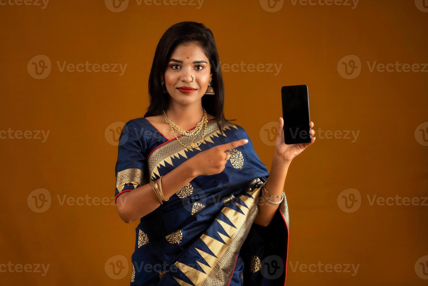 Young beautiful girl showing a blank screen of smartphone or mobile or tablet phone photo