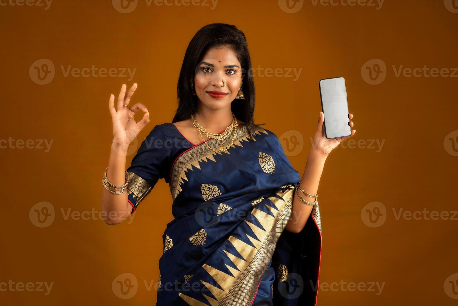 Young beautiful girl showing a blank screen of smartphone or mobile or tablet phone photo
