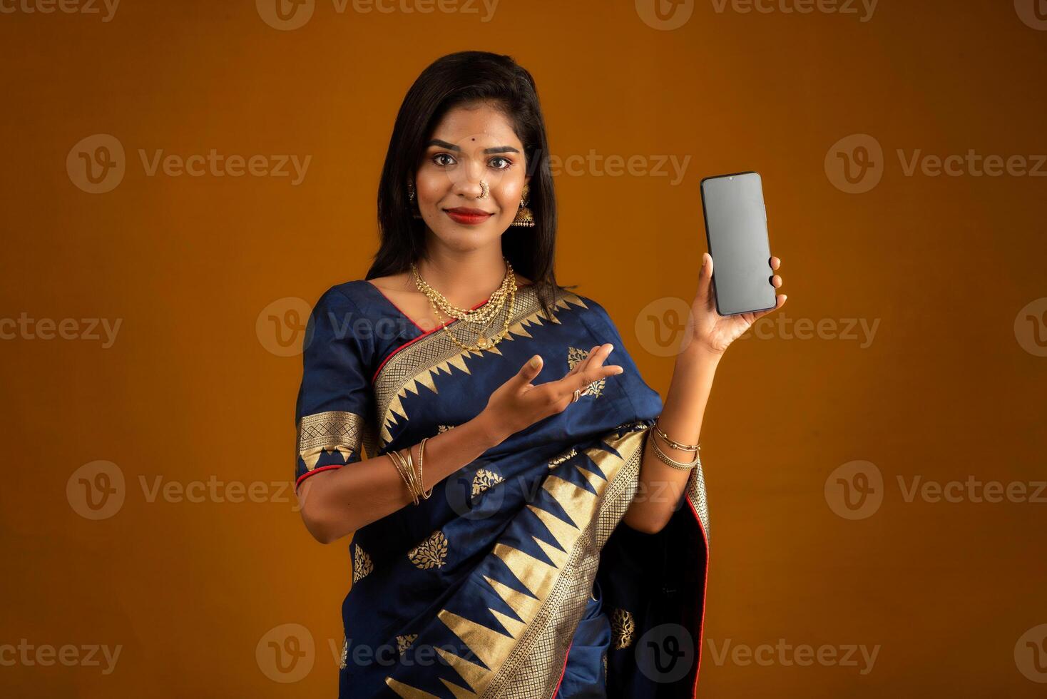Young beautiful girl showing a blank screen of smartphone or mobile or tablet phone photo