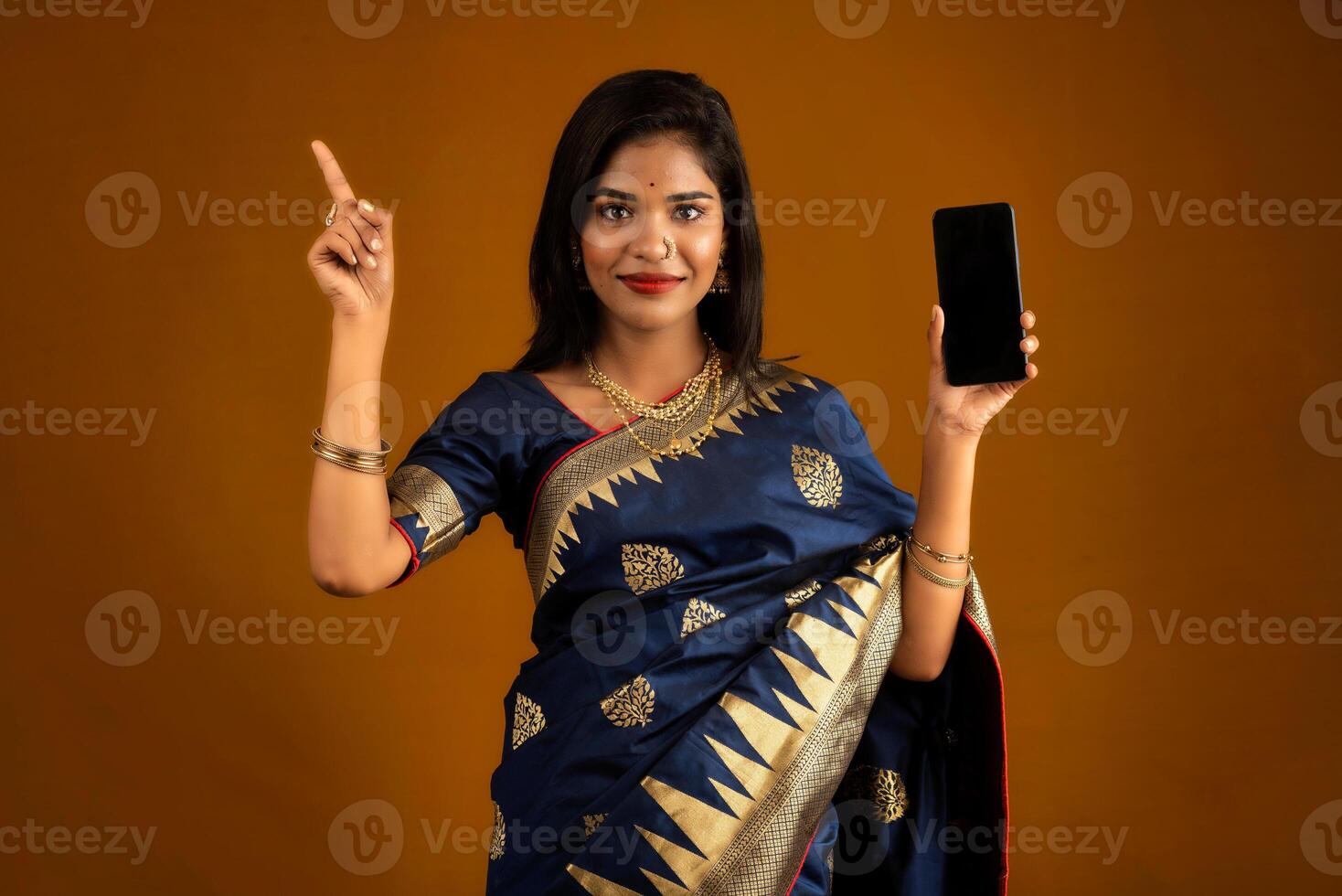 Young beautiful girl showing a blank screen of smartphone or mobile or tablet phone photo